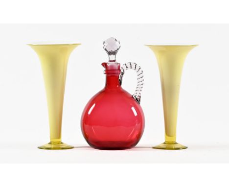 A Victorian cranberry glass decanter, with clear glass handle and stopper, together with a pair of yellow trumpet shaped vase