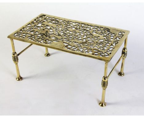 A 19th century brass rectangular trivet, the top decorated with deer hunting scene, initialled AB.  Height 17.5 cm, width 35 