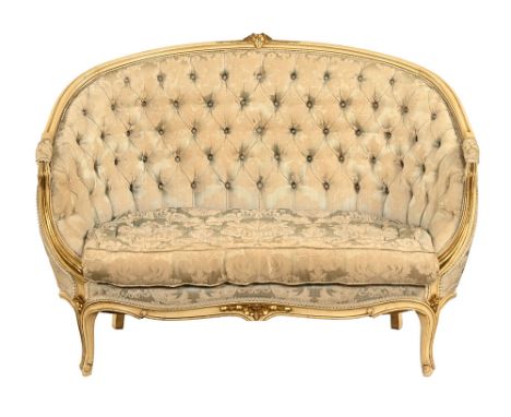 A continental gilded settee, with pale floral patterned material, deep buttoned back and cushion. Height 88 cm, width 122 cm,