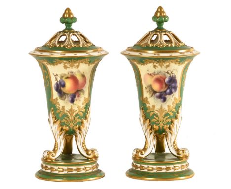 A pair of Royal Worcester vases and covers, 1919 shape No. 2519, the Campana body supported on three dolphin scroll acanthus 