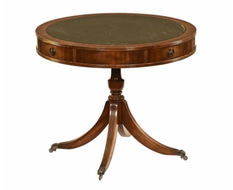 A drum table in the manner of Chapman's Siesta, with green leather tooled top and four drawers with circular handles raised o