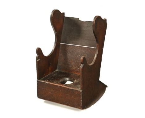 A 19th century oak child's rocking commode chair.&nbsp; Height 56 cm, width across arms 34 cm.