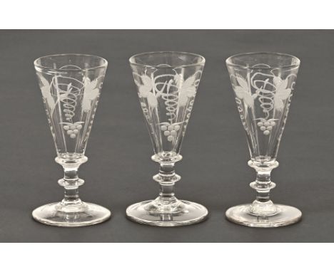 Three early 19th century fruiting vine engraved trumpet shaped glasses, each with knopped stem and circular foot.  Height 13.