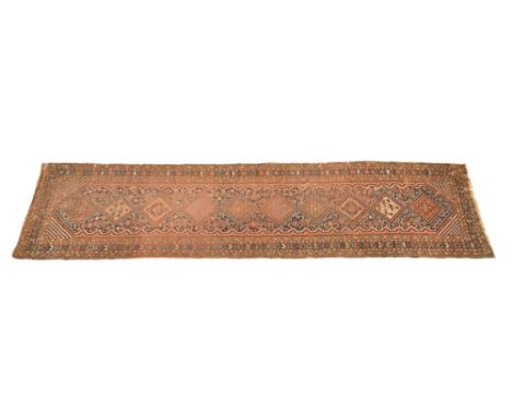 A vintage runner, with repeating border and central geometric design with central floral patterns, horses etc.  378 x 91 cm.