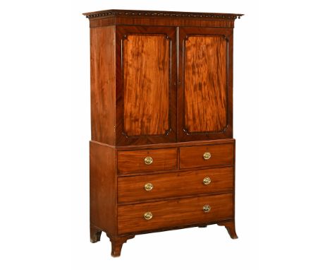 A George III mahogany linen press, with moulded cornice with applied balls, above a pair of panelled doors opening to trays, 
