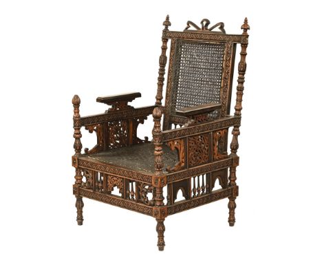 An Anglo Indian armchair, with bergere back and seat and fretwork panels. Height 102 cm, width 60 cm, depth 59 cm, seat heigh
