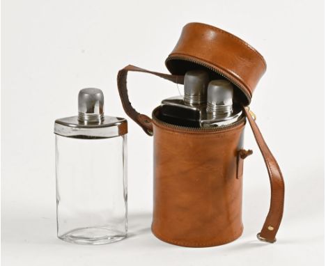 A cylindrical leather case, containing three glass spirit flasks with chrome plated mounts.  Case height 20 cm.