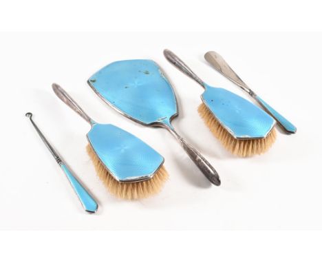 A pale blue guilloche enamel over silver five piece dressing table vanity set, two brushes, mirror, buttonhook and shoe horn,