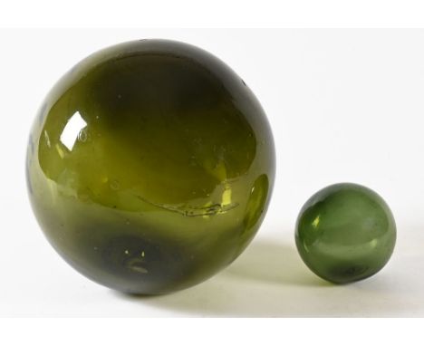 A large green glass hand blown fishing float.  Diameter circa 31 cm, with another smaller moulded with an anchor mark.