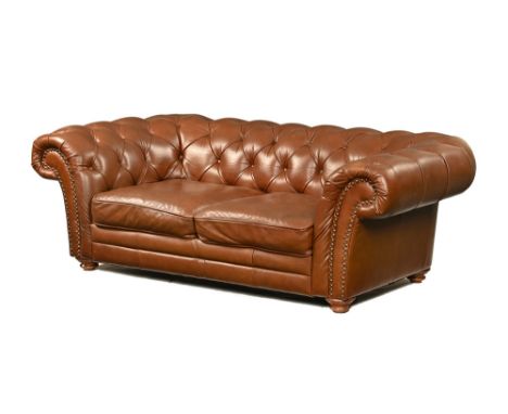 A tan leather Chesterfield settee, raised on turned wooden feet. Width 200 cm, depth 98 cm, seat height 40 cm (see illustrati
