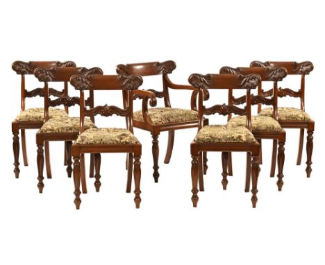 A set of seven Victorian dining chairs, with carved back rail and support and raised on turned tulip style legs upholstered i