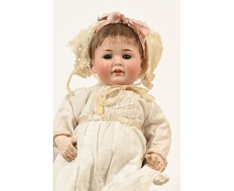 A late Victorian bisque headed doll, with moving eyes and impressed marks to rear of the head, dressed in a christening gown.