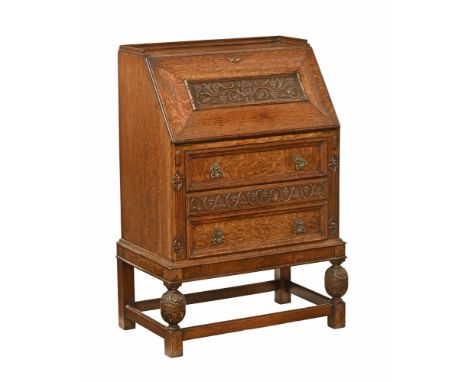 An early 20th century oak bureau, of unusual form with galleried back and carved slope opening to a moving fitted interior, t