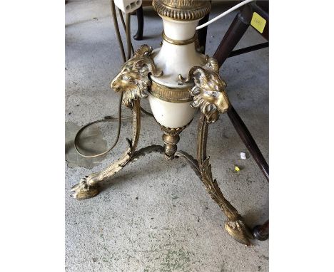 A marble and gilt metal standard lamp on three feet with ram detailing and marble table surround