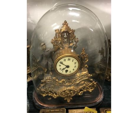 A Gilt clock under a glass dome