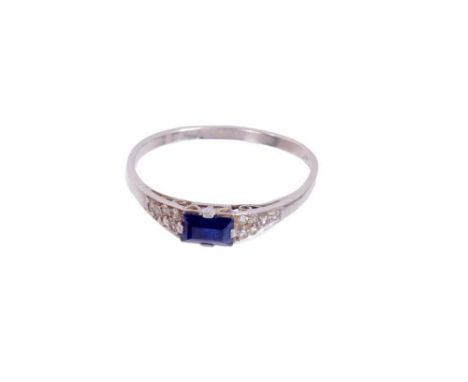 Art Deco sapphire and diamond ring with a rectangular step cut blue sapphire flanked by pavé set single cut diamonds to the s