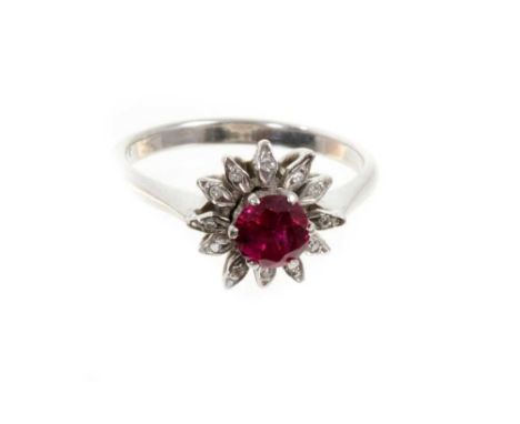 Ruby and diamond flower head cluster ring with a round mixed cut ruby surrounded by single cut diamonds to the stylized petal