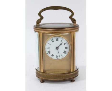 Edwardian brass cased carriage clock of oval form, with white enamel circular dial, 13cm high