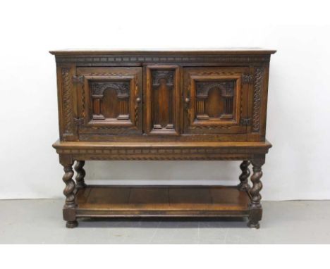 17th century and later oak cupboard on stand with central arched panel flanked by two arched panelled doors on stand with spi