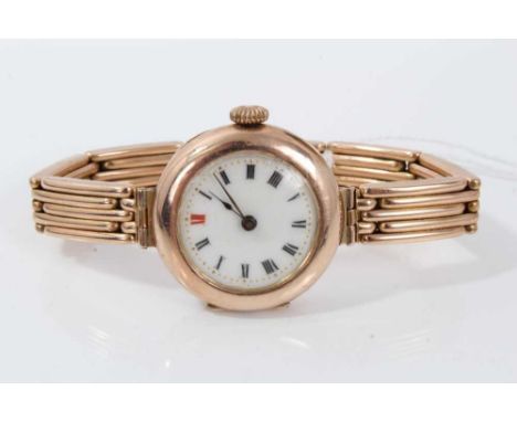 Edwardian ladies 9ct rose gold wristwatch with circular enamel dial in circular rose gold case on a rose gold bracelet with g