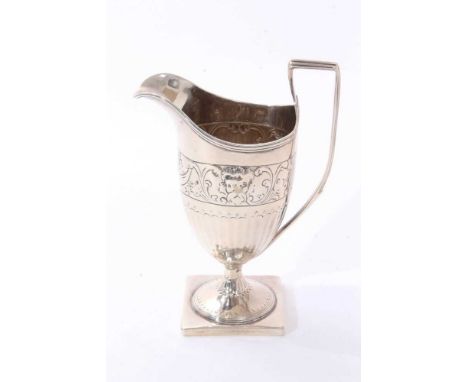 George III silver milk jug of helmet form, with half fluted and floral decoration and reeded handle, on a square pedestal bas