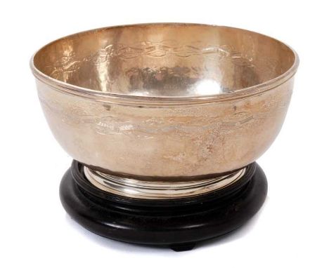 Contemporary silver rose bowl of circular form, with spot hammered finish, raised rim and stylized foliate decoration, on a c