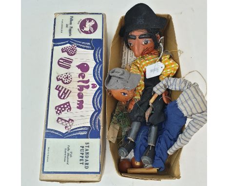 A Pelham puppet, Pirate, and another puppet, in a brown box (2) 