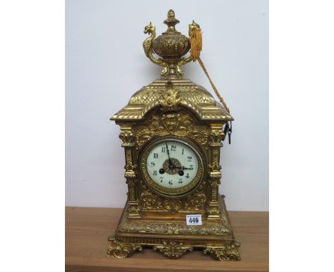 A heavy brass ormolu striking mantle clock, 48cm tall, with a key and pendulum, appears overwound 