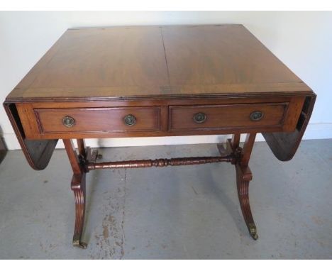 A late 19th century mahogany drop leaf sofa stretcher table with two active and two dummy drawers on twin supports - Height 7