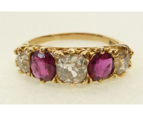 THREE STONE DIAMOND AND GARNET SET RING, claw set with three graduated old cut diamonds, 0.53ct approx. and smaller, and two 