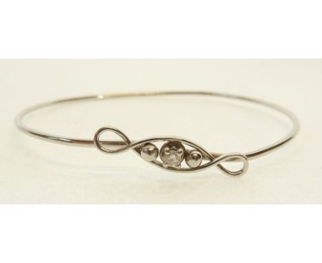 DIAMOND SET PLATINUM WIRE BANGLE, the twist pattern top claw set with a small brilliant cut diamond, 0.05ct approx., 5.5g 