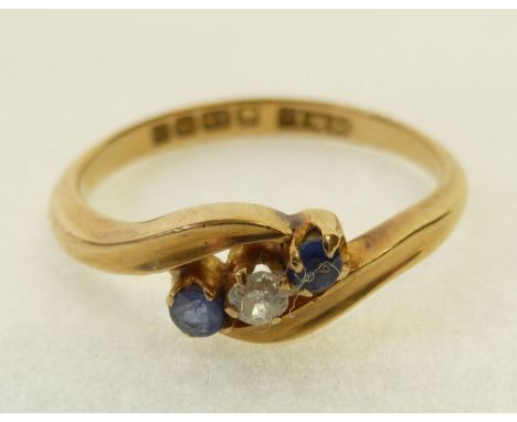 18CT GOLD, SAPPHIRE AND DIAMOND CROSS OVER RING, centre set with an old cut diamond, 0.03ct approx., flanked by two round cut