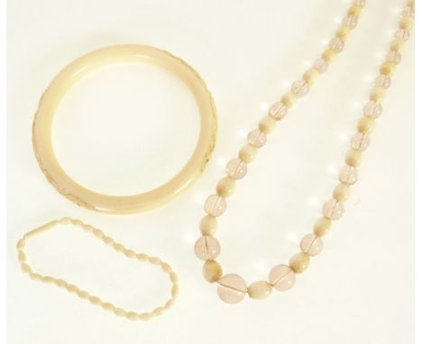 EARLY/MID TWENTIETH CENTURY NECKLACE OF GRADUATED OVAL IVORY AND PINK GLASS BEADS, 20" (51cm) long, A DRAGON CARVED IVORY BAN