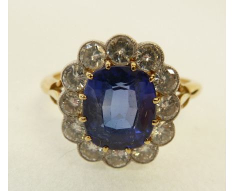 PROBABLY SAPPHIRE AND DIAMOND CLUSTER RING, the claw set cushion cut sapphire 2.60ct approx., with a cluster surround of twel