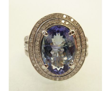 TANZANITE AND DIAMOND SET RING, four claw set oval mixed cut tanzanite, with a double row diamond set surround, and diamond s