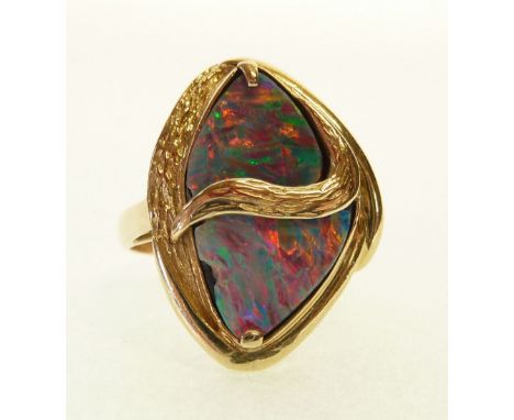 STAMPED 14CT GOLD OPAL SET RING, the oval shaped top with dividing textured gold band, set with two shaped opal slices (crack