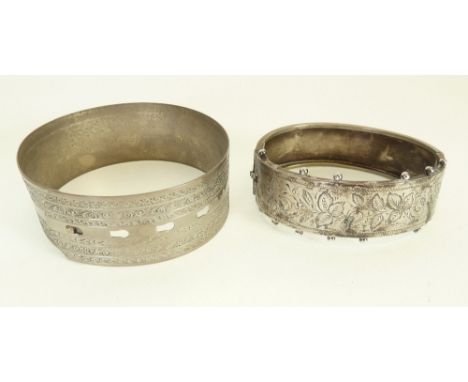 VICTORIAN SILVER HINGE OPENING BANGLE, foliate engraved with beaded edge (af) AND A VICTORIAN SILVER METAL BANGLE, with buckl