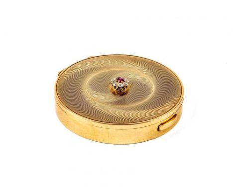 A CARTIER ART DECO 9CT GOLD CIRCULAR COMPACT, London 1945, the concentric circle engine turned cover centred by a ruby and di