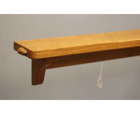 A ROBERT THOMPSON ADZED OAK WALL SHELF of rounded oblong form on ogee end brackets, carved mouse trademark in high relief, 82