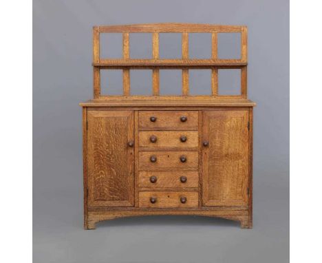 A SMALL HEALS STYLE ARTS AND CRAFTS SIDEBOARD, late 19th century, the mildly arched open panelled back with shallow shelf, th