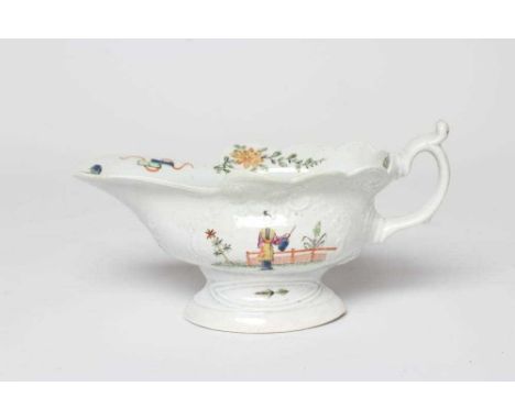 A WORCESTER PORCELAIN HIGH-FOOTED SAUCEBOAT, c.1755, of shaped oval form with moulded panels, painted in famille verte type e