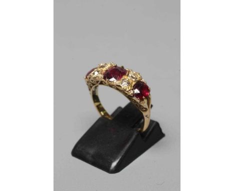A LATE VICTORIAN THREE STONE RUBY RING, the graduated circular facet cut stones claw set with four rose cut diamond points be