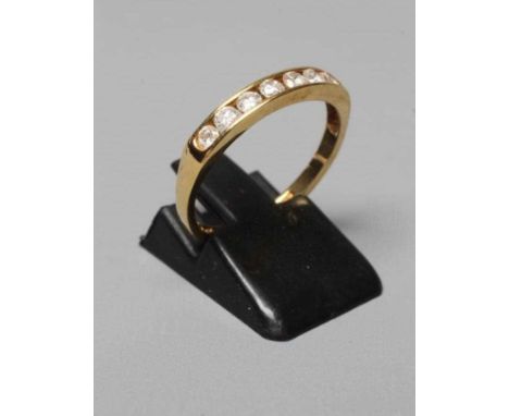 A SEVEN STONE DIAMOND HALF HOOP ETERNITY RING, the brilliant cut stones totalling 0.5cts, channel set to a plain 18ct gold sh