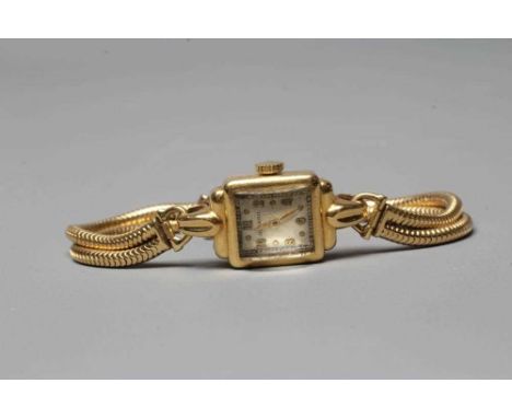 A LADY'S 18CT GOLD CASED MOVADO WRISTWATCH, the oblong cream dial with applied gilt metal even Arabic numerals, the unnumbere