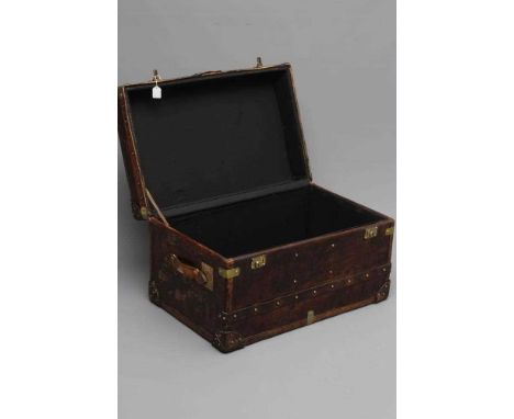A STUDDED TRAVEL TRUNK, early 20th century, made of wood and leather covered, with two side handles, 32" x 20" x 18 1/2" (Est