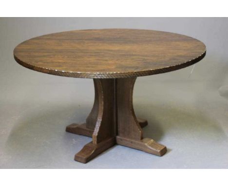 A DAVID LANGSTAFF ADZED OAK DINING TABLE, the circular top with adzed edge, raised on waisted cruciform base with sledge feet