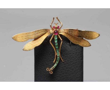 A DRAGONFLY BROOCH with engraved wings, facet cut ruby eyes and cabochon thorax, and channel set graduating calibre cut emera