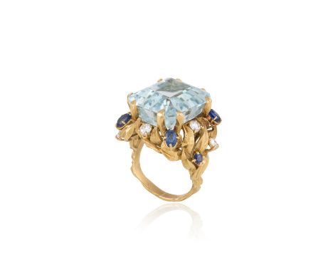 AN AQUAMARINE AND GEM-SET COCKTAIL RING, CIRCA 1970The rectangular step-cut aquamarine weighing approximately 19.00cts, withi