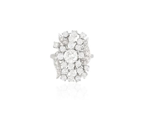 A DIAMOND DRESS RING, CIRCA 1960Designed as a stylised bouquet of flowers set with a central round brilliant-cut diamond, wit