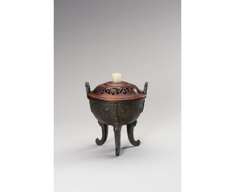 AN ARCHAISTIC DING-FORM BRONZE TRIPOD CENSERChina, the bronze vessel dating to the Ming Dynasty (1368-1644); the wooden lid a